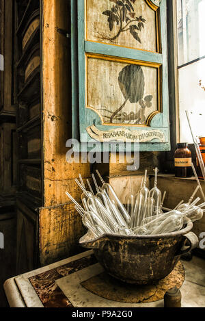 Rohre in einer Schale in der Nähe eines Fensters mit dem gemalten Verschluss in den hinteren Raum der Eingangshalle des alten Apotheke und Apotheke "Farmacia di S. Maria della Scala' in Piazza della Scala im Viertel Trastevere, Rom, Italien Stockfoto