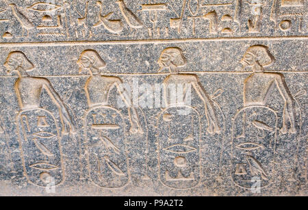 Nahaufnahme Detail der Alten Ägyptischen geschnitzten Figuren Hieroglyphe mit griechischen Skript Graffiti, Tempel von Luxor, Luxor, Ägypten, Afrika Stockfoto