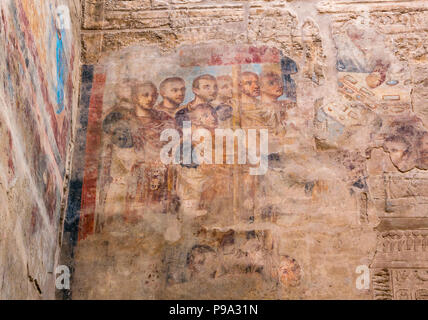 Koptisch-christliche Wandmalerei von Gesichtern über alte ägyptische Reliefs Tempel, Luxor, Ägypten, Afrika Stockfoto