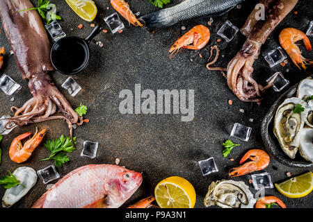 Frische rohe Meeresfrüchte squid Garnelen oyster Miesmuscheln Fisch mit Gewürzen der Kräuter Zitrone auf dunklen rusty Background Copy space Top View Stockfoto