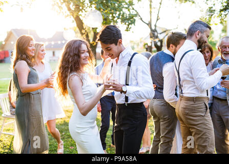 Die Gäste tanzen an der Hochzeit außerhalb im Hinterhof. Stockfoto