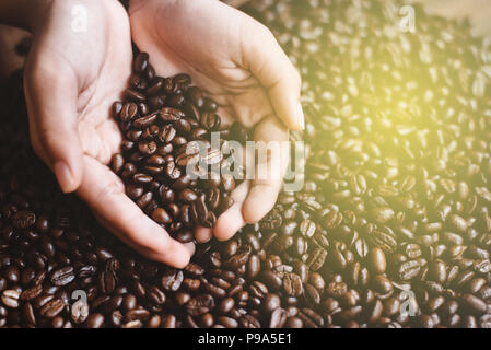 Hohen winkel Nahaufnahme von Mann mit Kaffeebohnen in hohlen Händen. Lieblingsgetränk und landwirtschaftlichen Konzept Stockfoto