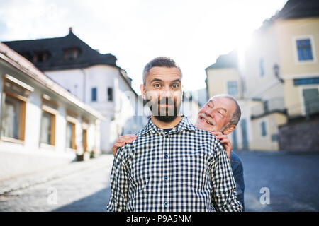 Ein erwachsener hipster Sohn mit dem Vater auf einen Spaziergang in der Stadt. Stockfoto