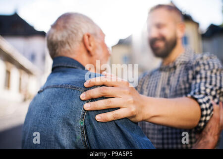 Ein erwachsener hipster Sohn mit dem Vater auf einen Spaziergang in der Stadt. Stockfoto