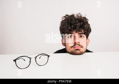 Kopf eines jungen Mannes und der Brille in einem Studio. Stockfoto