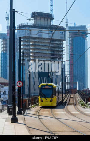 Die Achse und Deansgate Square Apartment Blocks (im Bau) mit einem Metrolink Tram im Vordergrund, von der unteren Mosley Street, Manchester, UK Stockfoto