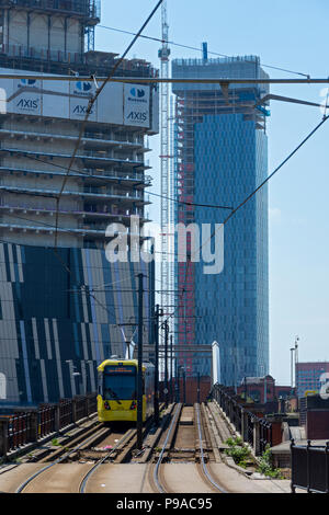 Die Achse und Deansgate Square Apartment Blocks (im Bau) mit einem Metrolink Tram im Vordergrund, von der unteren Mosley Street, Manchester, UK Stockfoto