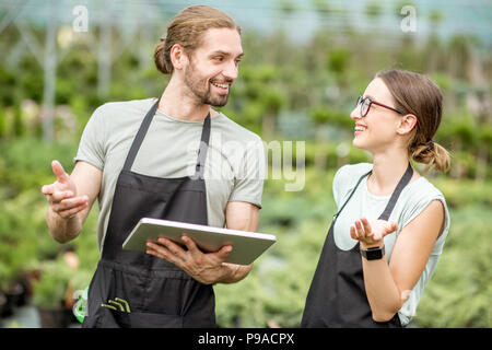 Arbeitnehmer mit Tablet im Gewächshaus Stockfoto