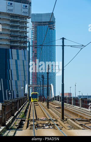 Die Achse und Deansgate Square Apartment Blocks (im Bau) mit einem Metrolink Tram im Vordergrund, von der unteren Mosley Street, Manchester, UK Stockfoto