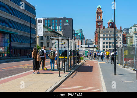 Eine Bushaltestelle mit "Niederländisch" Stil der Radweg hinter sich, Oxford Road, Manchester, England, Großbritannien Stockfoto