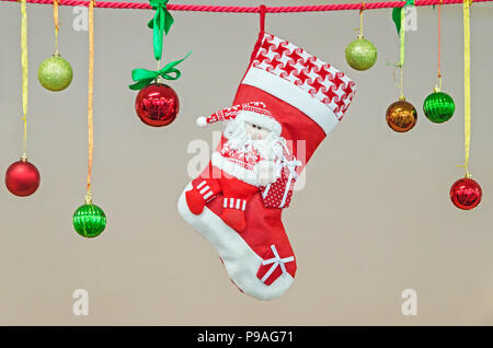 Festliche Weihnachten Socke Warten auf den Weihnachtsmann hing an einer Schnur mit Weihnachtsverzierungen Stockfoto