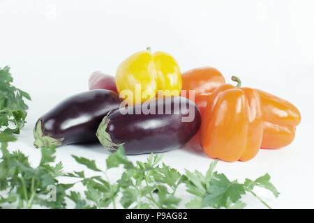 Paprika, Auberginen und Zweige Petersilie auf einem weißen backgroun Stockfoto