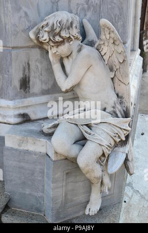 Junge Engel warten durch eine Gruft, in La Recoleta Friedhof in Buenos Aires, Argentinien. Stockfoto