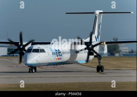 Eine Flybe Bombardier Dash 8 Q400 Taxis entlang der Start- und Landebahn am Flughafen Manchester während der Vorbereitung, sich zu entfernen. Stockfoto