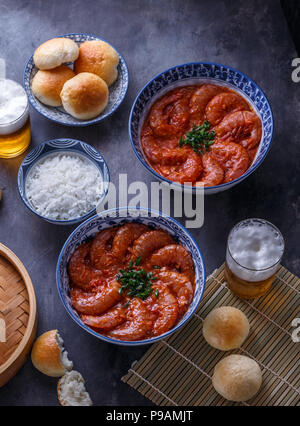 Langustinen in pikanter Chili suace mit Reis und gedämpfte Brötchen, asiatische Küche Stockfoto