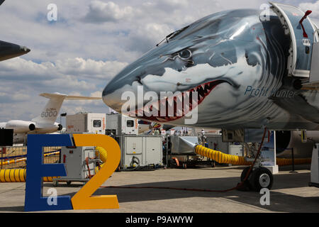 Farnborough, Großbritannien. 16. Juli 2018. Eine Embraer 190 E2 tragen ein Hai spezielle Lackierung auf der Nase des Flugzeugs sitzt am Eröffnungstag der Farnborough International Airshow 2018, einer der größten Luftfahrt Industrie- und Ereignisse in der Welt, in das Vereinigte Königreich gehalten geparkt. Credit: James Hancock/Alamy leben Nachrichten Stockfoto