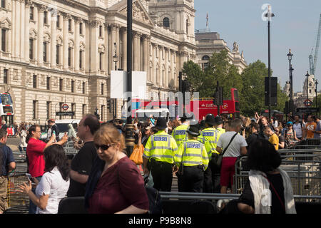 Rückansicht - London Polizei eingesetzt als Sicherheitsmaßnahme während der Protest Oberseite Trumpf' in London, Großbritannien mit Red London Bus im Hintergrund. 13/07/2018. Stockfoto