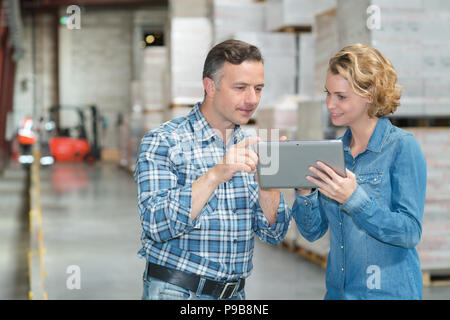 Lagerleiter, Blick auf Tablet-pc in ein großes Lager Stockfoto