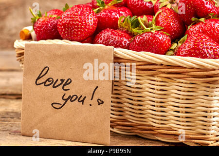 Korb gefüllt mit reifen Erdbeeren. Süße gesunde Erdbeeren und handschriftlichen Text liebe dich. Liebe Beichte Konzept. Stockfoto