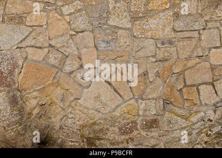 Sandsteinmauer mit Moos im Sonnenschein Stockfoto