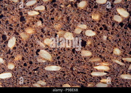 Poröse Abschnitt der dunkles Brot mit Sonnenblumenkernen closeup, können als Hintergrund oder Textur verwendet werden. Stockfoto