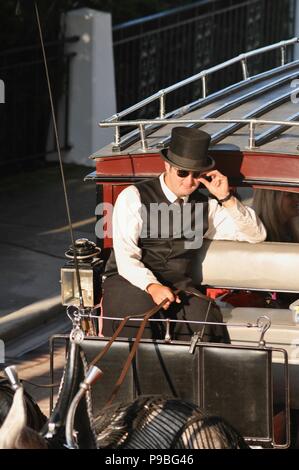 Pferd Treiber (Kutscher) in Schwarz top hat auf Rot, Kutsche an der historischen Grand Hotel resort insel Mackinac Island, Michigan, USA. Stockfoto