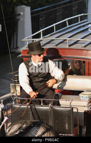 Pferd Treiber (Kutscher) in Schwarz top hat auf Rot, Kutsche an der historischen Grand Hotel resort insel Mackinac Island, Michigan, USA. Stockfoto