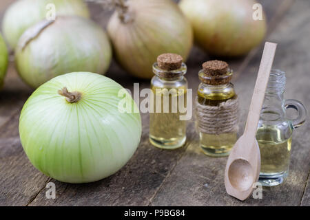 Zwiebel Saft und Gemüse auf einem Holztisch. Hausgemachte Sirup für die Behandlung der Grippe. Der dunkle Hintergrund. Stockfoto