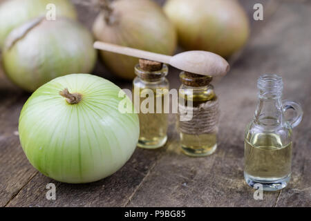 Zwiebel Saft und Gemüse auf einem Holztisch. Hausgemachte Sirup für die Behandlung der Grippe. Der dunkle Hintergrund. Stockfoto