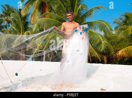 Fischer mit Net in den frühen Morgen am tropischen Strand, Indien Stockfoto