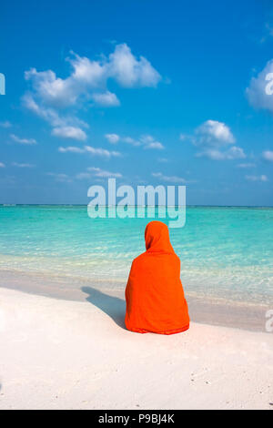 Frau mit Kopftuch sitzen auf wunderschönen tropischen Strand Stockfoto
