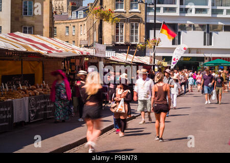 Leute, surfen und wandern vorbei an outdoor Marktstände in der Market Street, Cambridge, Großbritannien Stockfoto