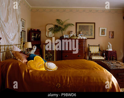 Seide Golddeckung auf Bett im 30er Jahre Stil Schlafzimmer Stockfoto