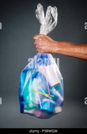 Hand, die eine Tasche von Kunststoffabfällen Stockfoto