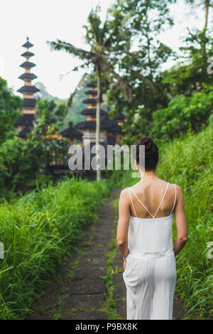 Junge schöne Frau zu Fuß auf campuhan Ridge weg von Künstlern, auf Bali, in Ubud. In der Nähe von traditionellen Tempel Stockfoto