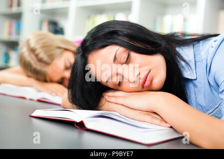 Müde Schüler schlafen in Bibliothek Stockfoto