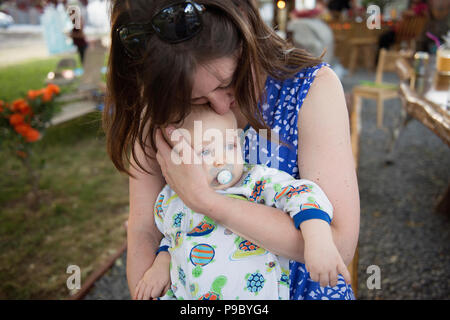 Eine Mutter ihre ein Jahr alte Kind umarmt. Stockfoto