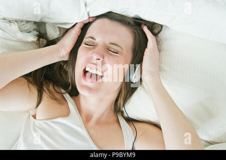 Eine Frau, die Musik auf Ihre Kopfhörer und Singen. Stockfoto
