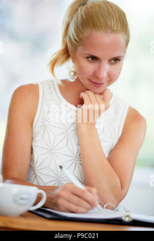 Frau in ein Tagebuch zu schreiben Stockfoto