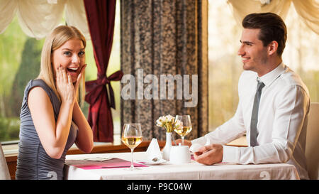 Glückliches Paar im Restaurant, Mann schlägt seine Freundin Stockfoto