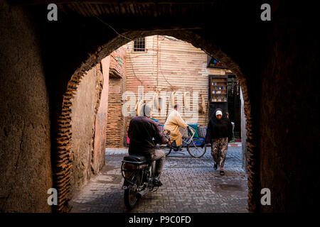 Marrakesch, Marokko - November 06, 2017: Menschen zu Fuß auf einer kleinen Straße in Marrakesch mit einem Souvenirshop im Hintergrund Stockfoto