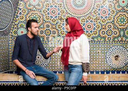 Junge muslimische Paare in Beziehung reden und lächeln, Hände vor Arabesque orientalische Dekoration Stockfoto