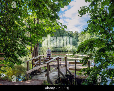 Nicht erkennbare Mann angeln in der City Park entlang der Fluss Motala in Norrköping. Norrköping ist eine historische Stadt in Schweden. Stockfoto