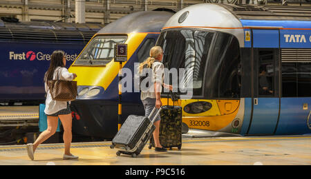 Fahrgäste entlang eine Plattform am Londoner Bahnhof Paddington und dem Heathrow Express an Bord Stockfoto