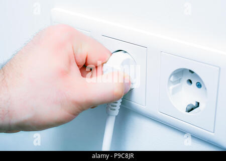 Ziehen Sie einen Stecker aus der Steckdose Energie sparen Stockfoto