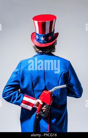 Uncle Sam-Figur von hinten mit einem Benzin pumpe Düse hinter seinem Rücken gesehen. Stockfoto