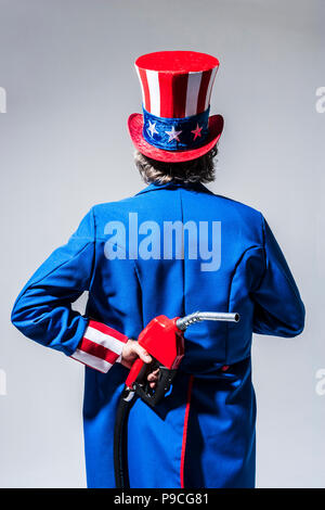 Uncle Sam-Figur von hinten mit einem Benzin pumpe Düse hinter seinem Rücken gesehen. Stockfoto