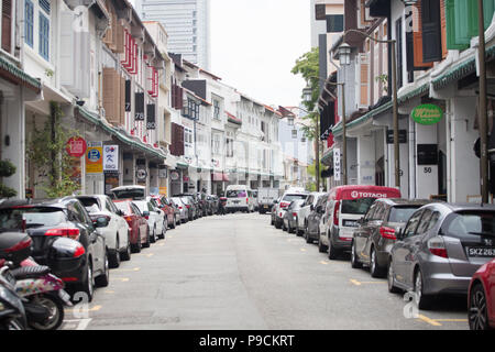 Die Einbahnstraße ist voll mit Fahrzeugen, die an den Seiten vor dem Ladengeschäft geparkt werden. Singapur. Stockfoto