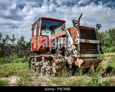 Alte kaputte Traktor mit Raupenantrieb in das Feld verlassen Stockfoto