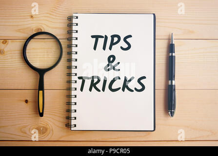 Tipps und Tricks text auf Notizblock mit Stift und Lupe Stockfoto